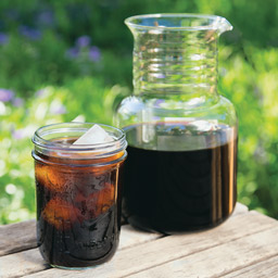 Toddy cold brew coffee extract in mason jar next to Toddy cold brew system 
